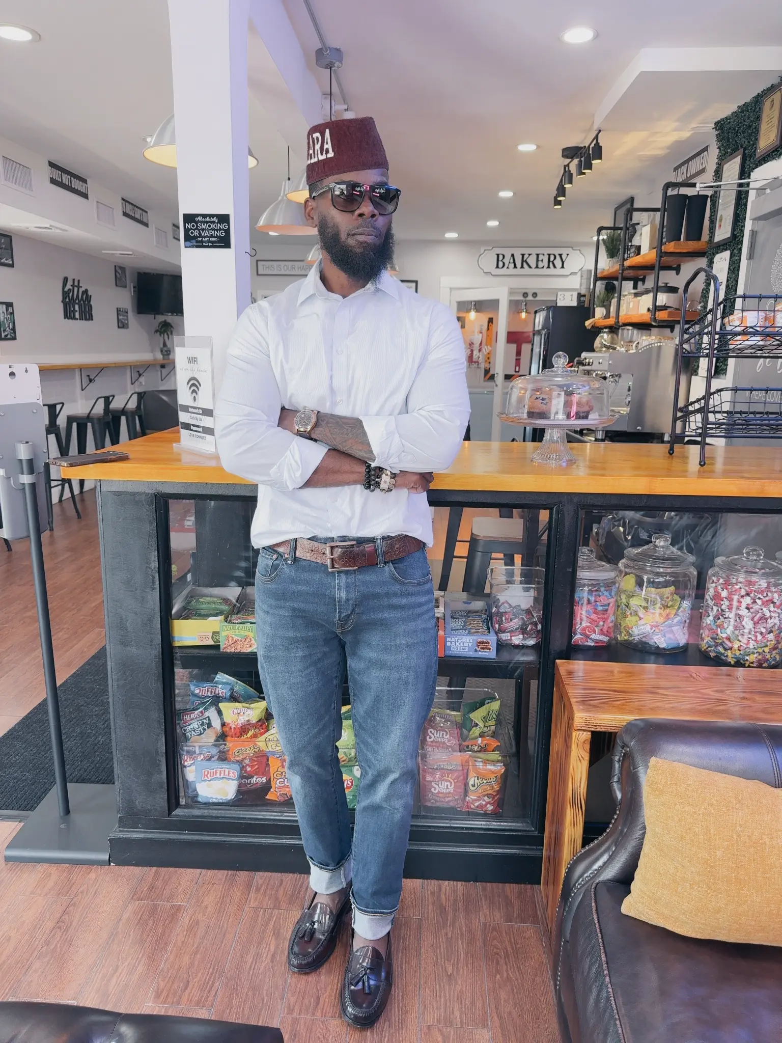 Samuel Breaker, founder of Cafe By Us!!!, standing confidently in his cafe