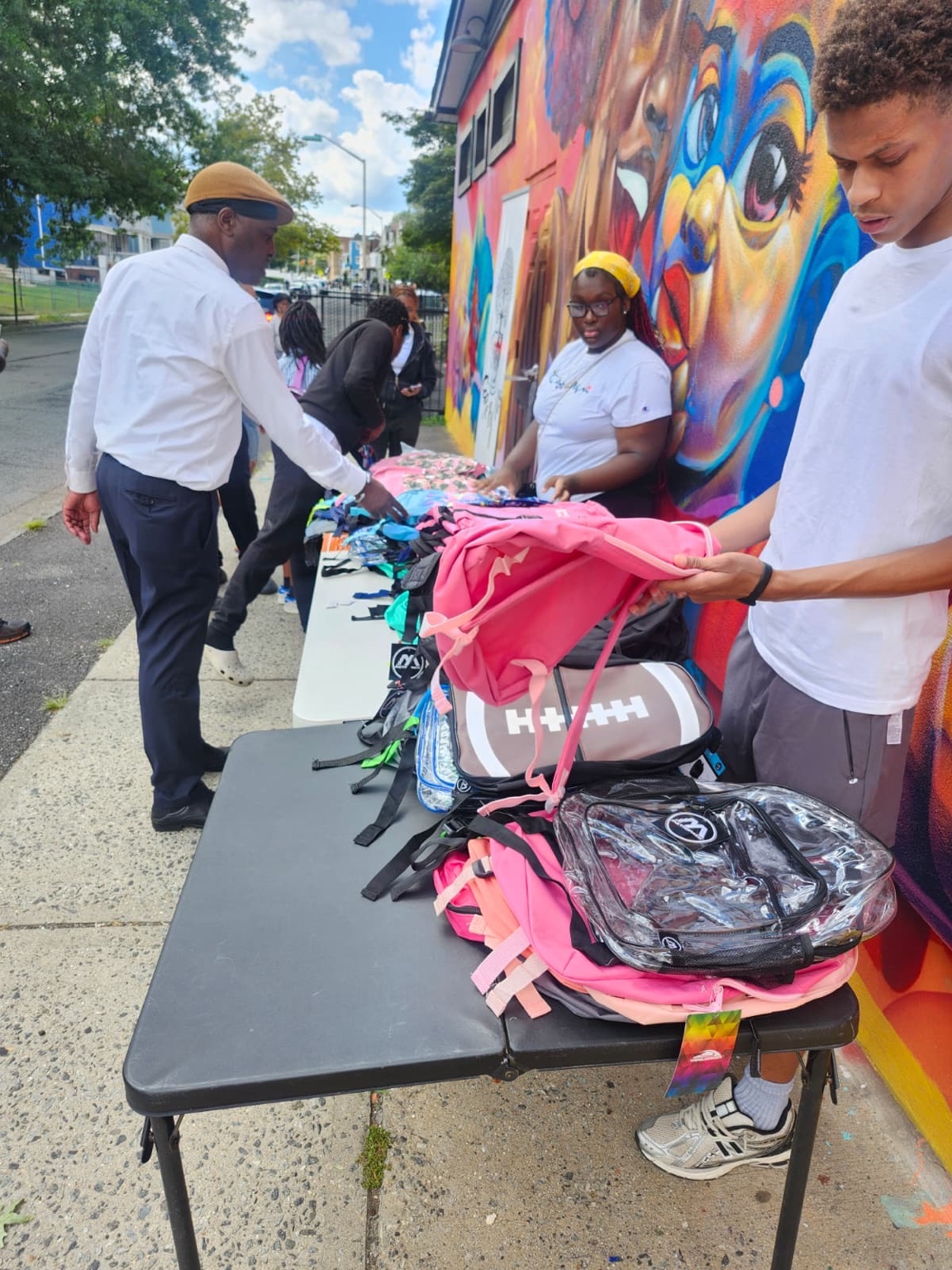 Back-to-school backpack giveaway outside Cafe By Us